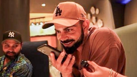 Indian cricket team member Virat Kohli speaks on the phone during a call with Prime Minister Narendra Modi after winning the ICC Men's T20 World Cup 2024. Modi spoke to the Indian cricket team on the phone on Sunday and congratulated its members on their World Cup win. 