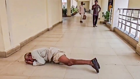 A farmer with folded hands rolls on the floor to reach the District Collector's office to lodge his complaint after his land was allegedly taken by a mafia, in Mandsaur district, Wednesday, July 17, 2024.