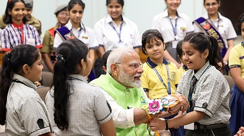 School children tie Rakhi on the wrist of Prime minister Narendra Modi.