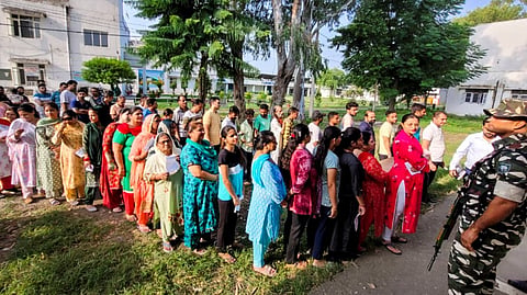 Voters wait in a queue to cast votes at a polling station during the third and final phase of the Jammu and Kashmir Assembly elections, in Bandipora district.