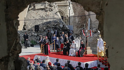 Listens to Mosul and Aqra Archbishop Najib Mikhael Moussa during a gathering to pray for the victims of war at Hosh al-Bieaa Church Square, Mosul