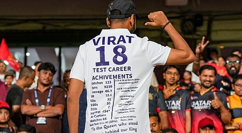 A fan of Royal Challengers Bengaluru's Virat Kohli wears a number 18 white jersey, showing his stats and achievements, in his honour after he recently announced retirement from the test cricket