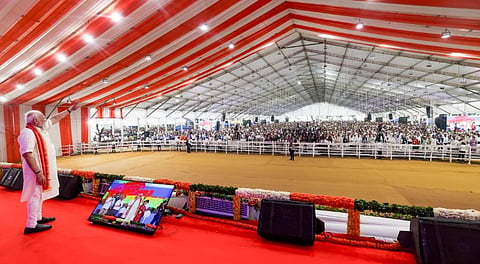 In this image received on Aug. 25, 2025, Prime Minister Narendra Modi waves to the gathering during the inauguration and foundation stone laying ceremony of development projects, at Khodaldham ground, in Ahmedabad.