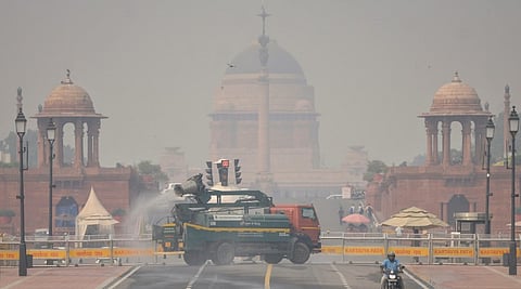 An anti-smog gun sprays water droplets to curb air pollution, with Rashtrapati Bhavan in the backdrop, as air quality deteriorates across northern India, in New Delhi, Tuesday, Oct. 21, 2025.