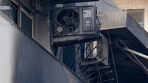 Charred remains of outdoor AC units and other items lie in the balcony of the four-storey residential building where a fire killed at least nine people, at Vivek Vihar area, in New Delhi, Sunday, May 3, 2026.