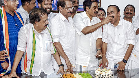 Leader of the Opposition VD Satheesan accepts sweets from KC Venugopal following the Kerala Assembly election results, while senior leaders including Shashi Tharoor,  Ramesh Chennithala and Sunny Joseph look on.