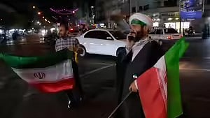 People take to the streets of Iran's capital, waving national flags to protest attacks by the US and Israel.