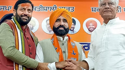 Haryana Chief Minister Nayab Singh Saini, left, BJP Punjab president Sunil Jakhar, right, with Punjab CM Bhagwant Mann's cousin Gyan Singh Mann during the latter's joining of the Bharatiya Janata Party, in Chandigarh, Monday, May 11, 2026.