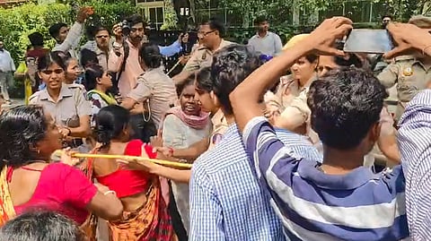 Residents and family members gather outside a building and protest following the murder of a woman whose body was found on the terrace of a residential building in the Greater Kailash area, in New Delhi, Thursday, June 18, 2026.