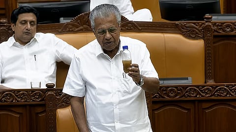 Pinarayi Vijayan showing in the State Assembly a sample of the waste water allegedly used by police in water cannons fired against opposition protesters.