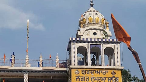 Nihangs stand on the roof of a gurdwara as part of their protest demanding the release of four members of the Sikh sect arrested following a clash in Chamoli district, in Rudraprayag, Uttarakhand, Monday, June 22, 2026.