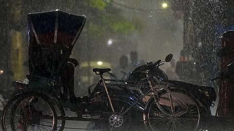 A man sits in his rickshaw during heavy monsoon rains, in Lucknow, Uttar Pradesh, Sunday, July 5, 2026.