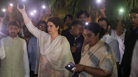 Congress leader Priyanka Gandhi Vadra and opposition MPs switch on torches on their mobile phones at the Gandhi Smriti, in New Delhi, Thursday, July 23, 2026.