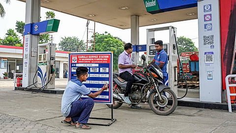 A worker updates the revised prices of petrol and diesel at a petrol pump, in Nadia, West Bengal.