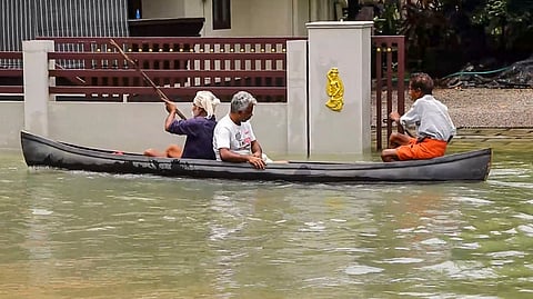 A man rows a country boat as he wades through a waterlogged road after heavy rainfall lashed parts of Kerala, in Kottayam district, Tuesday, Aug. 4, 2026.