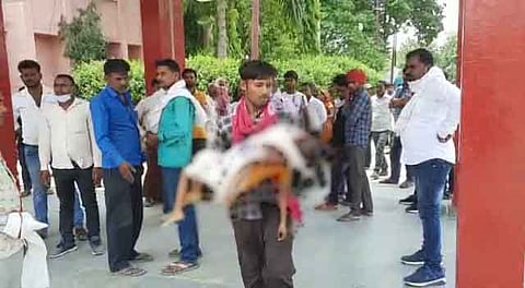 गोद में बेटे का शव लिए दौड़ता हुआ पिता 