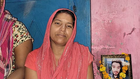 मनीष की फोटो के सामने बैठी उसकी मां [फोटो- पूनम मसीह, द मूकनायक]