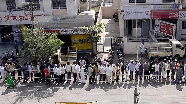 Endless queues of cashless people at ATMs