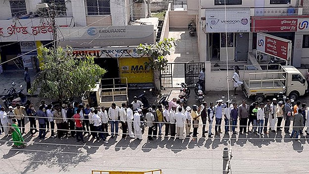 Endless queues of cashless people at ATMs