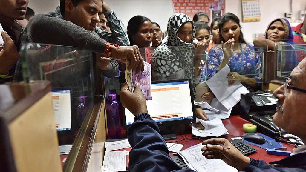A banker exchanges defunct currency notes at a PNB branch,  New Delhi