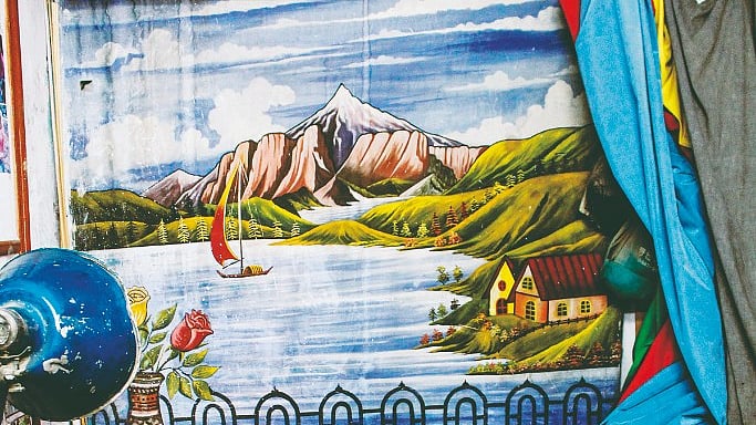 Hand-painted backdrop in Daoud’s Welcome Studio on Cinema Road. The blue curtain is for official portraits, while the red and yellow are decorative&nbsp;