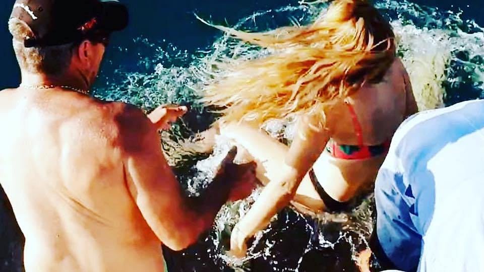 Narrow escape: Woman feeding sharks dragged in water by one, video goes viral