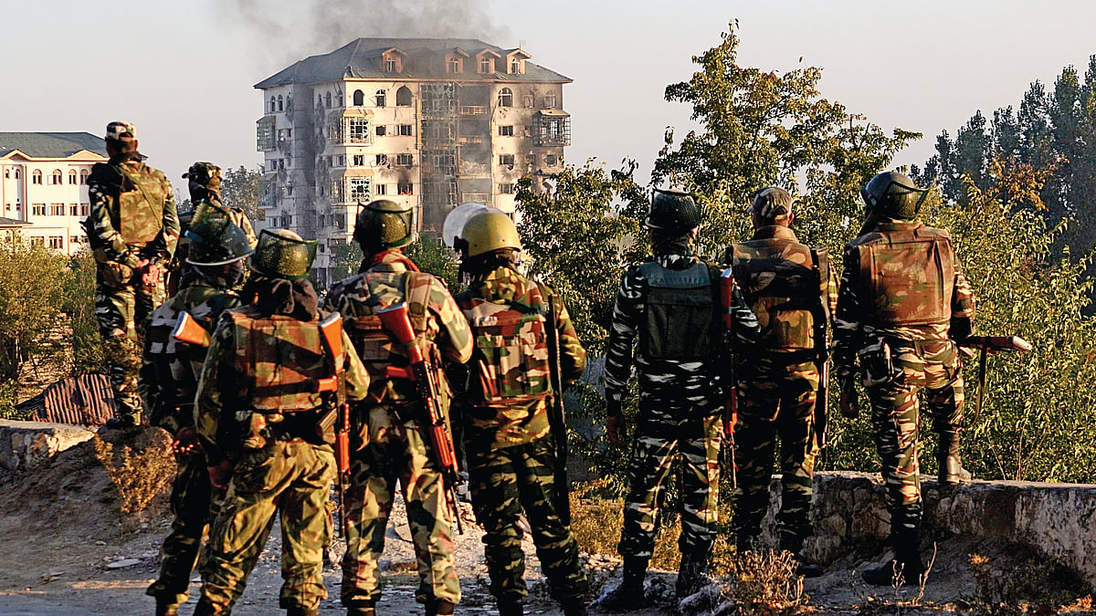 Soldiers look towards smoke billowing from a building where suspected militants had taken refuge during a gun battle in Pampore, on the outskirts of Srinagar&nbsp;