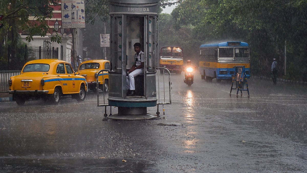 A traffic police personnel sits inside a kiosk during rainfall (Photo: National Herald archives)