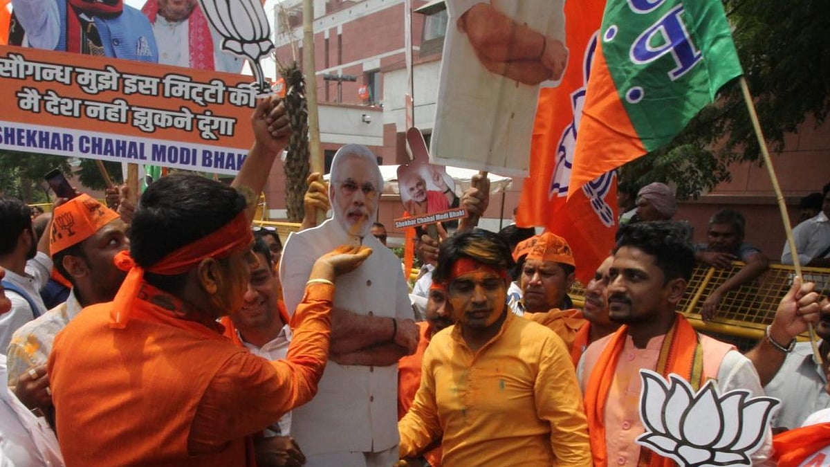 BJP supporters celebrate outside party headquarter in New Delhi as trends showed saffron party marching to a landslide victory.