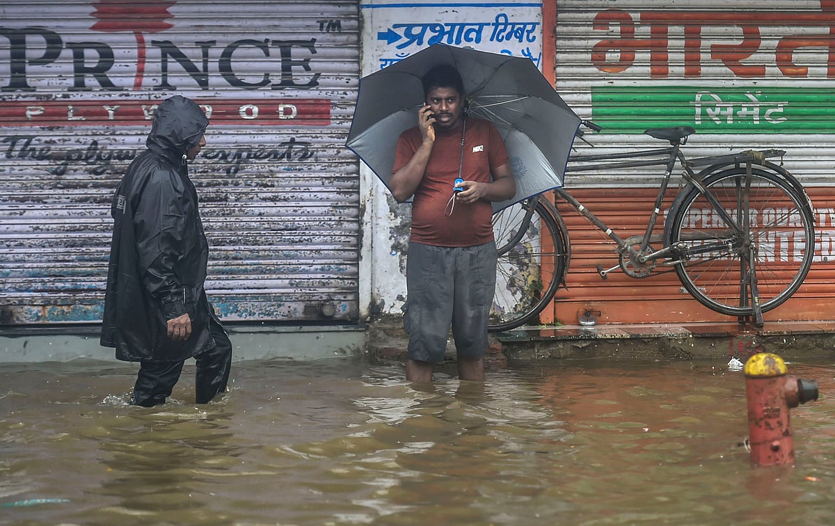  Pedestrians wade through a waterlogged street during monsoon rain, in Mumbai (PTI)