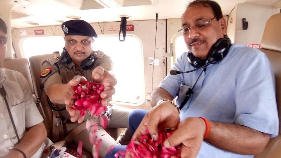 After foot massage by Sr. police officials, now Ghaziabad DM showers flower petals on Kanwariyas from chopper