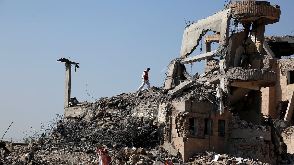 A rescue worker searches for victims in the rubble of a prison building hit by Saudi-led airstrikes in Yemen’s Dhamar province on Sept. 4, 2019 (IANS)