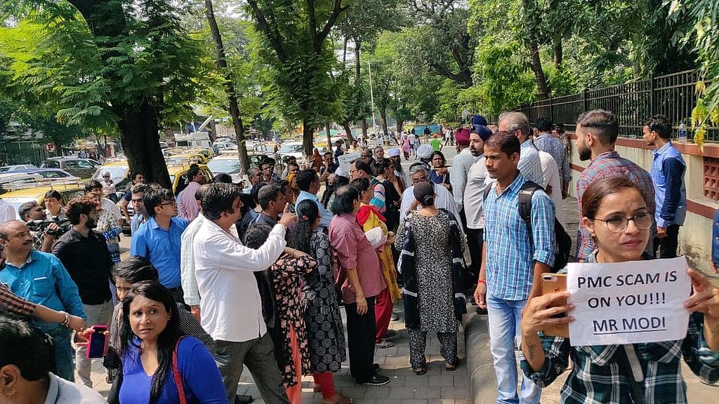 PMC Bank protestor holds placard that says “PMC Scam is on you, Mr Modi”
