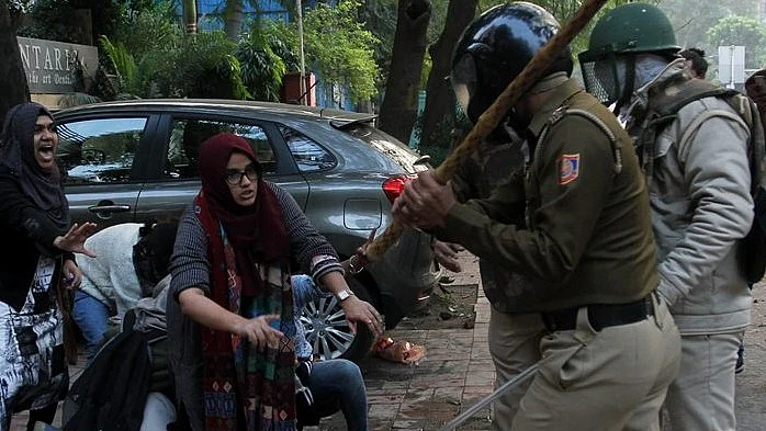The two girls standing up to policemen who are brutally raining batons at one and all during anti-CAA protest (Photo Courtesy: social media)
