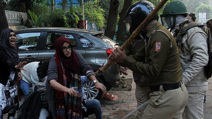 The two girls standing up to policemen who are brutally raining batons at one and all during anti-CAA protest (Photo Courtesy: social media)