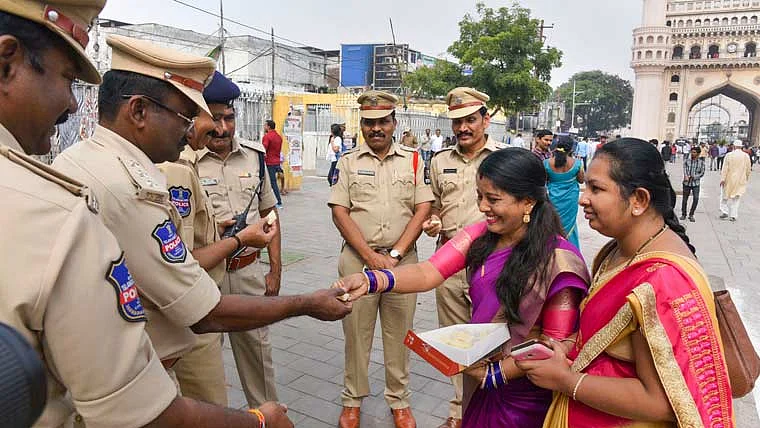Women distributing sweets to policemen in Hydeabad after the encounter killing of all the four rape-and-murder accused of a vet.