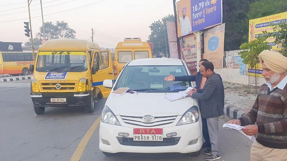 A tranport officer challans school vehicles for violating traffic rules in Patiala on Monday morning.