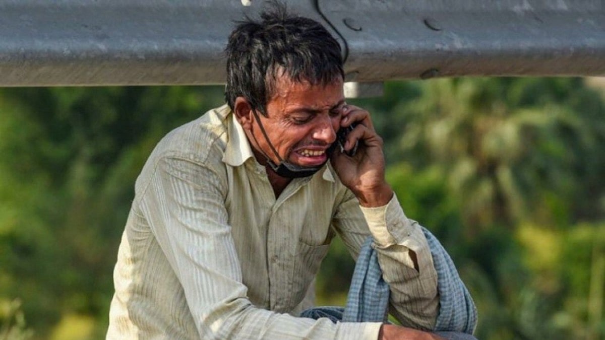 A migrant labourer crying while talking on the phone in Delhi