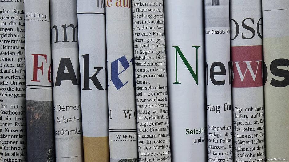 Newspapers rolled and lined next to each other so the letter visible on each paper adds up to say 'Fake News' (DW)