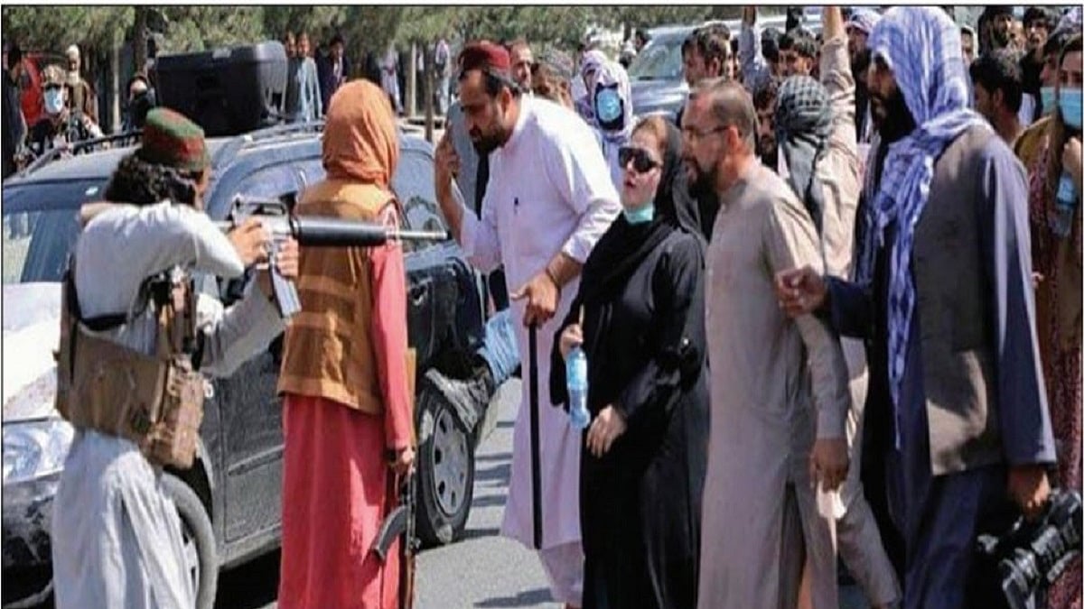 Taliban pointing a rifle at a woman