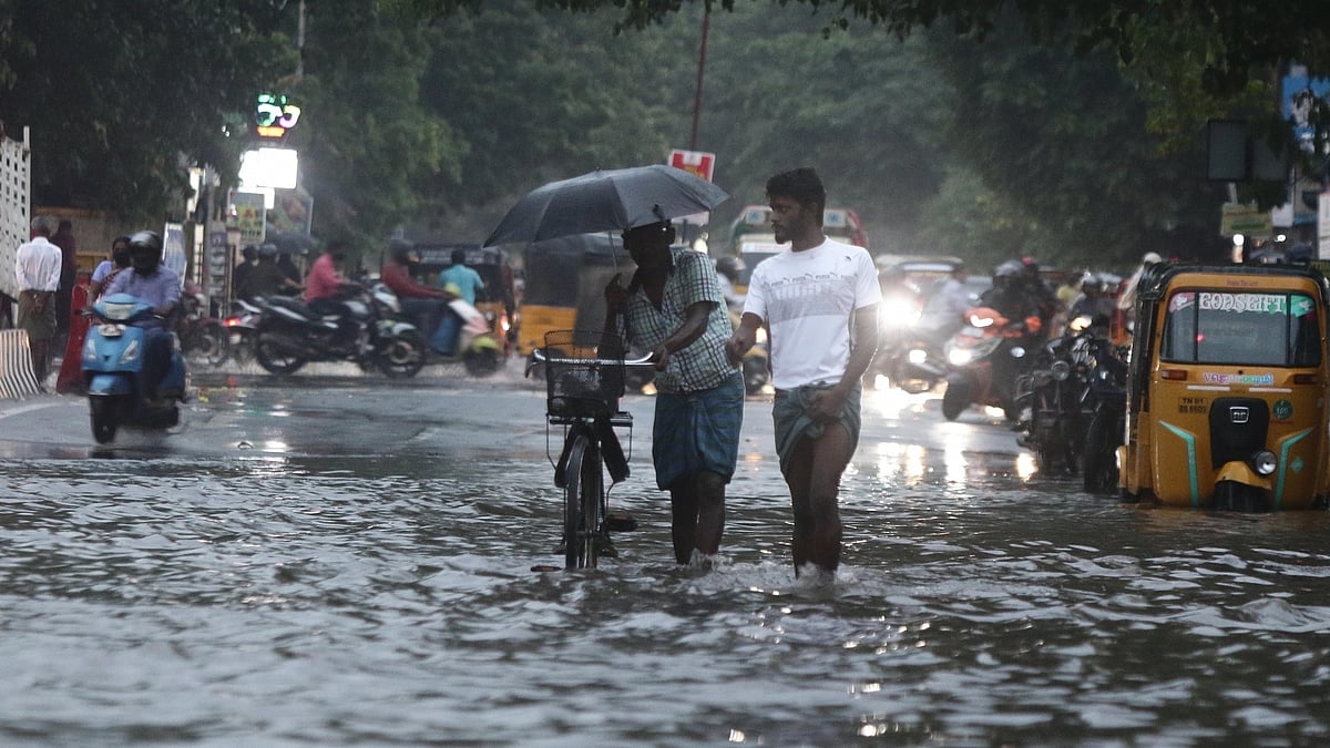 Commuters wade through the waterlogged streets of Chennai