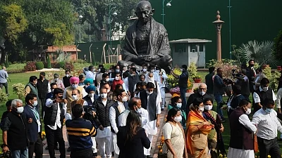 Opposition leaders hold a protest near Gandhi statue demanding repeal of three farm laws on the opening day of the winter session of Parliament in New Delhi, on Monday