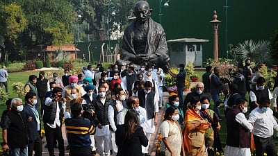 Opposition leaders hold a protest near Gandhi statue demanding repeal of three farm laws on the opening day of the winter session of Parliament in New Delhi, on Monday