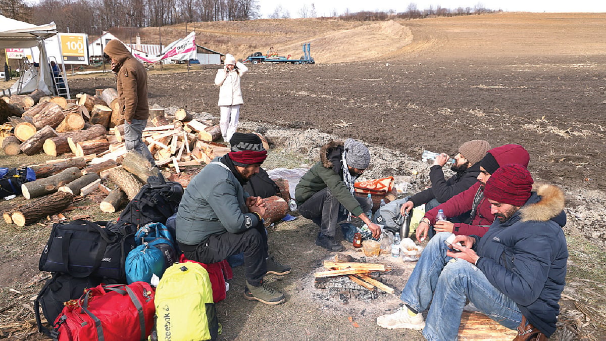 Indian students prepare food around a campfire near Hrebenne, Poland on March 1