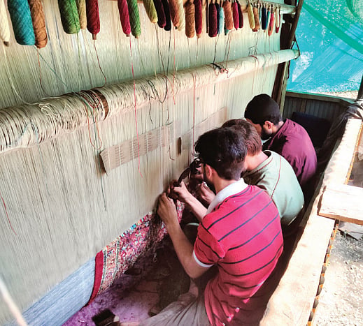 Kashmiri craftsmen at work. A 10-hour work day yields just a few centimetres of carpet (Photo: Mudassir Kulooƒ)