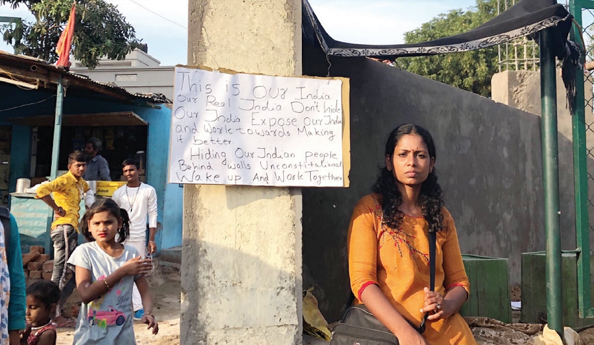 An activist protests against a wall built in front of a slum in Ahmedabad before US President Donald Trump's visit in February 2020 (Photo: Getty Images)
