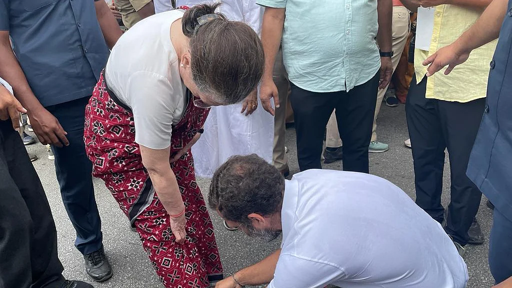 Congress leader Rahul Gandhi ties the shoelace of his mother, party president Sonia Gandhi, before she begins the Bharat Jodo Yatra in Mandya on Thursday