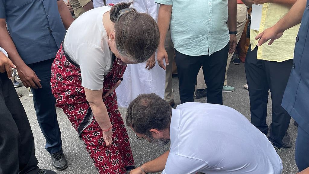 Congress leader Rahul Gandhi ties the shoelace of his mother, party president Sonia Gandhi, before she begins the Bharat Jodo Yatra in Mandya on Thursday