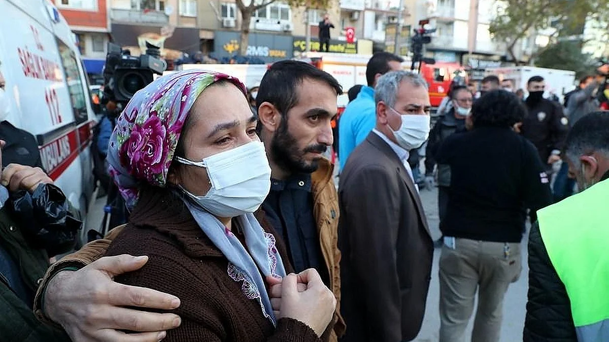 People wait anxiously for news from their relatives before a collapsed building