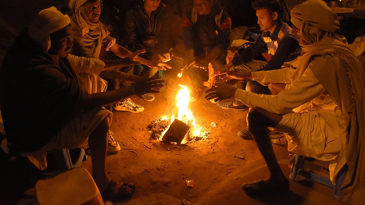 People warm themselves around a fire on a cold night in Jaipur, Rajasthan. (Photo: Ravi Shankar Vyas/IANS)